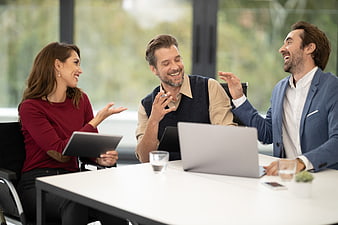 Happy business team laughing and talking in modern office meeting