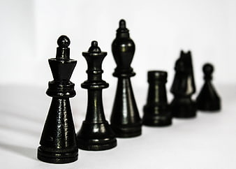 Black Chess Pieces in a Row on White Background