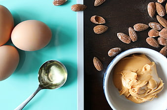 Healthy cooking ingredients including eggs, oil, almonds, and peanut butter