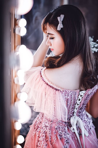 Young Asian Woman in Pink Dress by Vanity Mirror