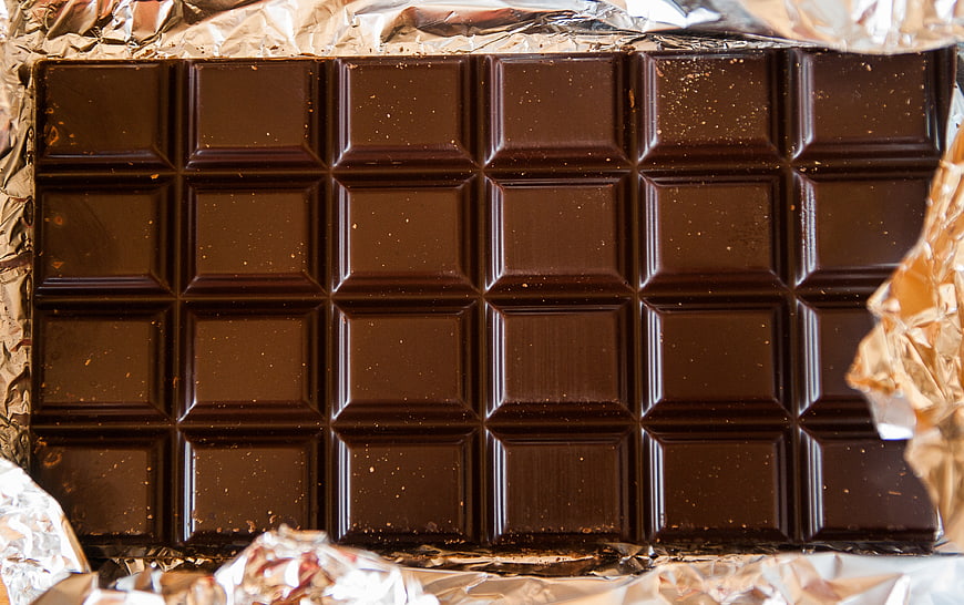 Close-up of dark chocolate bar on gold foil