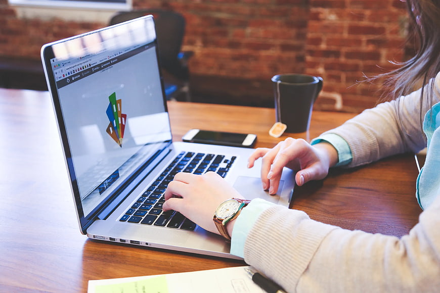 Woman typing on laptop in modern office workspace