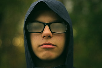 Close-up portrait of a young man in a hoodie and glasses