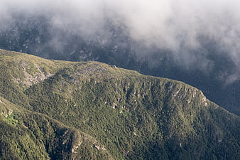Misty Mountain Ridge with Green Forest and Clouds
