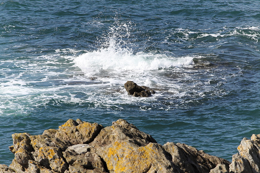 Ocean waves crashing against rocky coastal cliffs