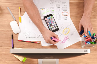 Top view of UX designer working on mobile app wireframes