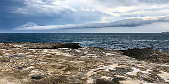 Dramatic coastal landscape with rocky shore and cloud formation