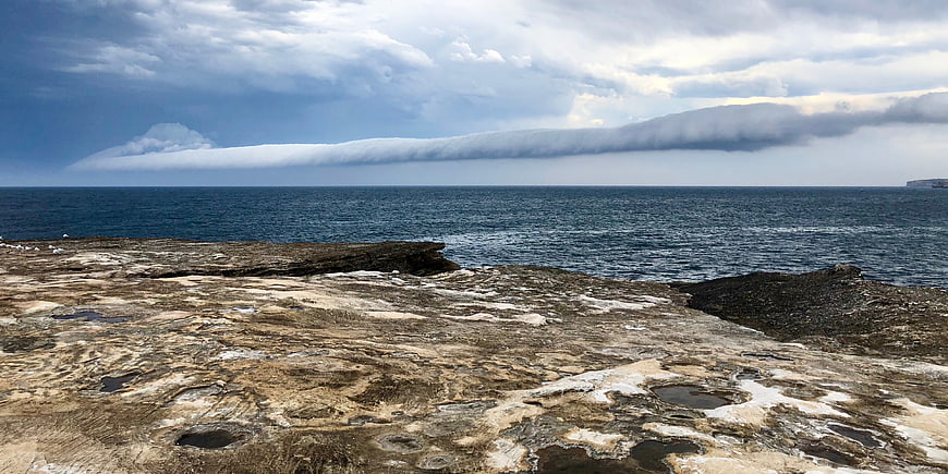 Dramatic coastal landscape with rocky shore and cloud formation