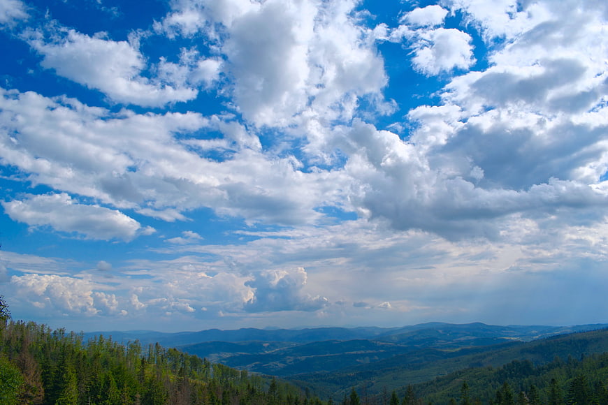 Dramatic Cloudy Sky Over Rolling Green Mountain Forest Landscape