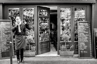 Man Smoking Outside Parisian Restaurant Entrance