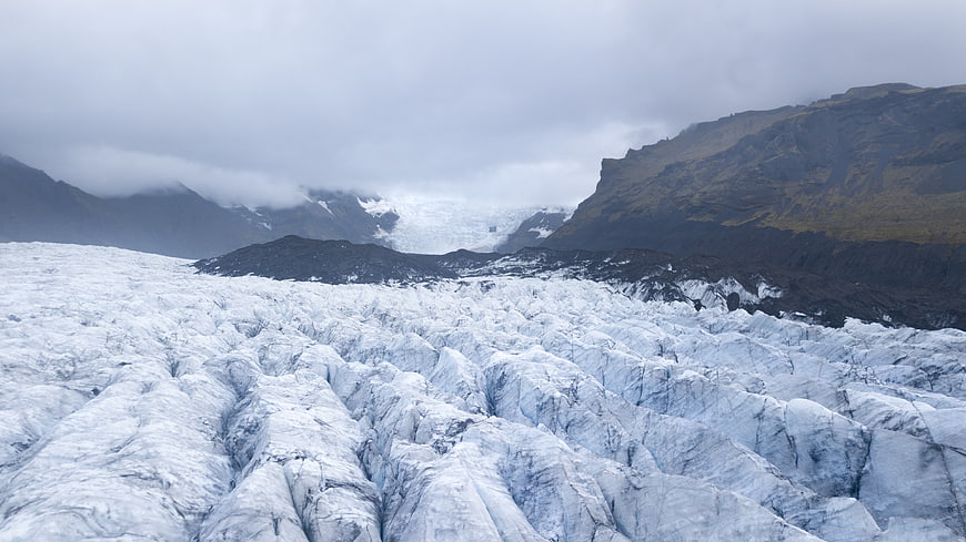 Vast Glacier Landscape with Cracked Ice and Mountains