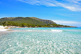 Cala Agulla Beach in Mallorca with Turquoise Water and Green Hills