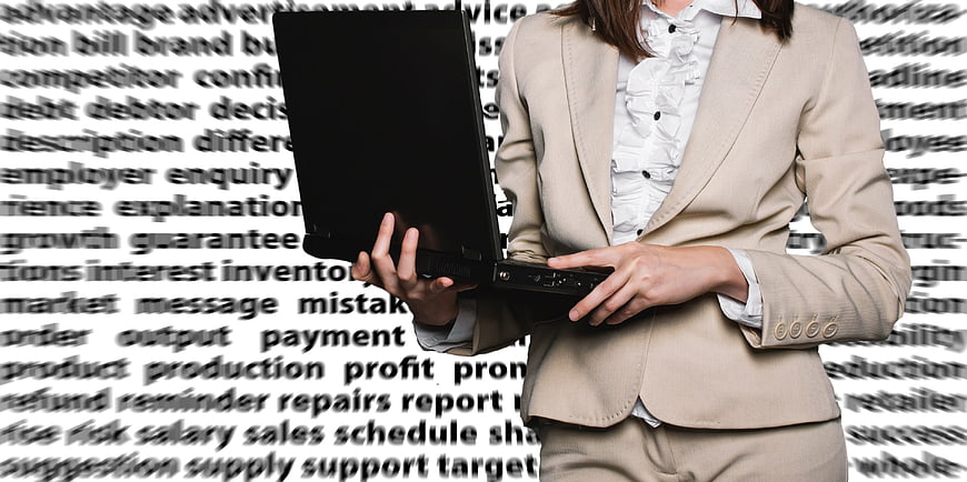Businesswoman holding laptop against business word cloud background