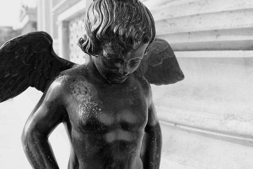 Black and white close-up of a bronze angel statue