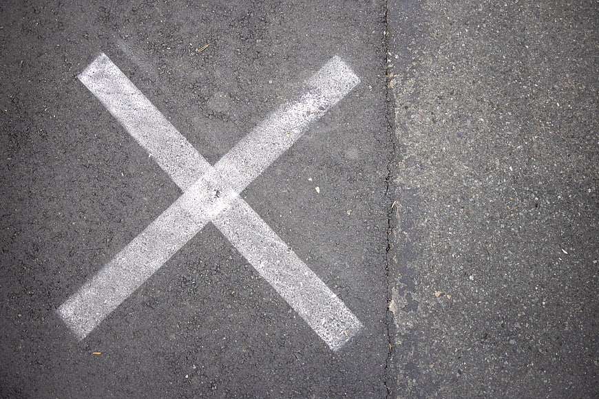 White X Mark Painted on Asphalt Road Surface