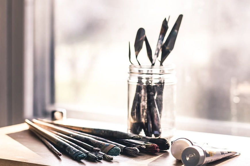 Art Supplies on Wooden Table by Window