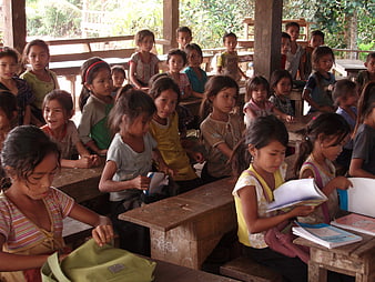 Young students in a rural wooden classroom in Laos