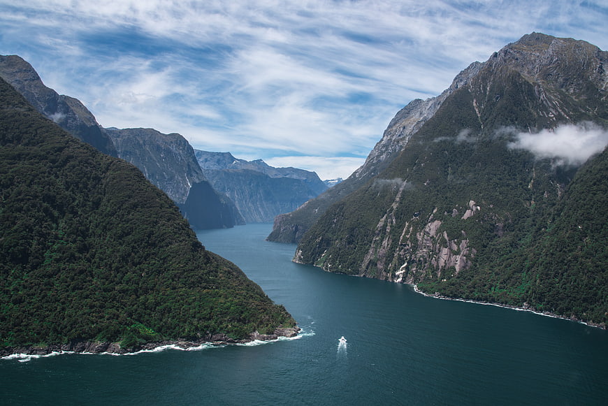 Aerial View of Majestic Fjord with Lush Mountains and Boat