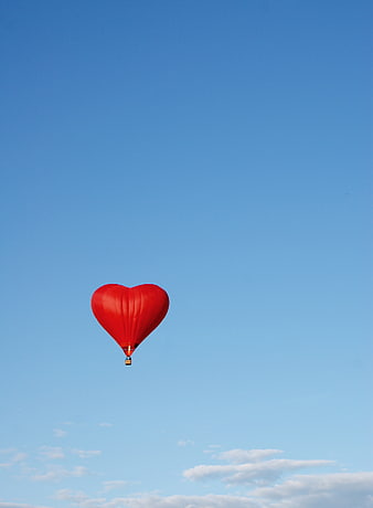 Red Heart-Shaped Hot Air Balloon Floating In Blue Sky
