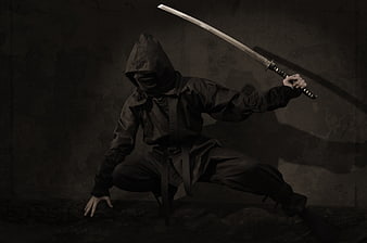 Hooded Ninja Warrior with Katana in Dark Studio