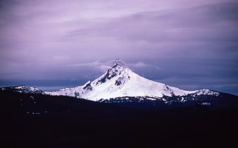 Snow-Capped Mountain Peak Against Purple Cloudy Sky