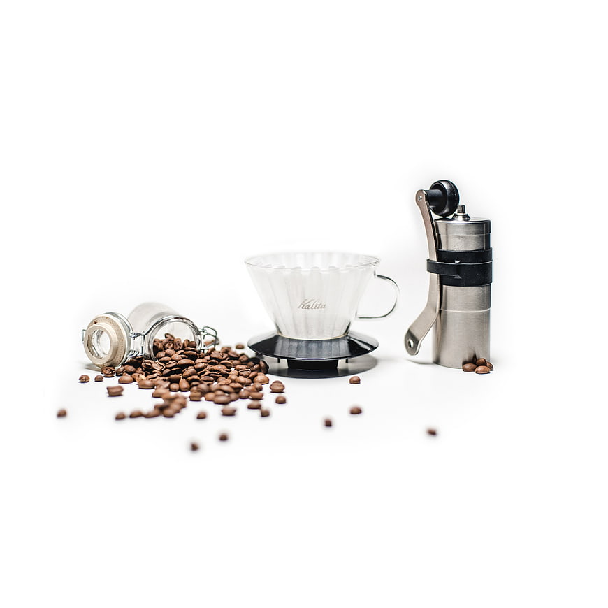 Coffee brewing setup with Kalita dripper, manual grinder, and beans