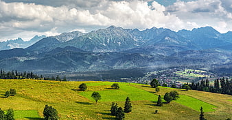 Panoramic View of Green Hills and Tatra Mountains Under Cloudy Sky