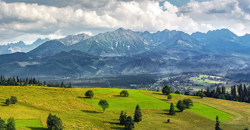 Panoramic View of Green Hills and Tatra Mountains Under Cloudy Sky