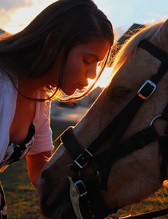 Woman Kissing Horse Head at Sunset