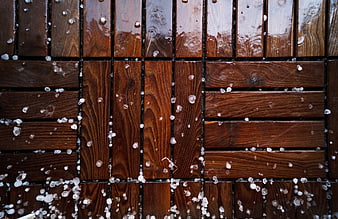 Hailstones on wet wooden deck planks