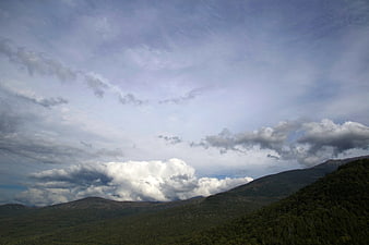 Dramatic Clouds Over Green Mountain Range Landscape