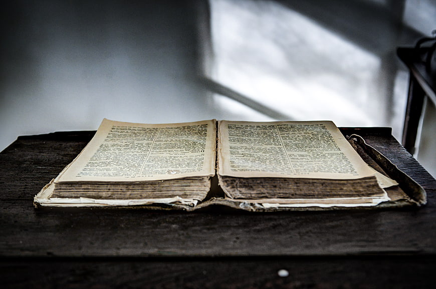 Vintage Open Bible on Dark Wooden Table