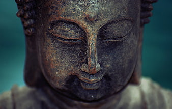 Close-up of weathered bronze Buddha statue face