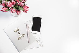 Flat lay workspace with pink tulips, notebook, and smartphone