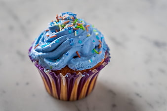 Blue Frosted Cupcake With Colorful Sprinkles On Marble Surface