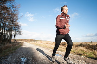 Man jogging on gravel road in countryside