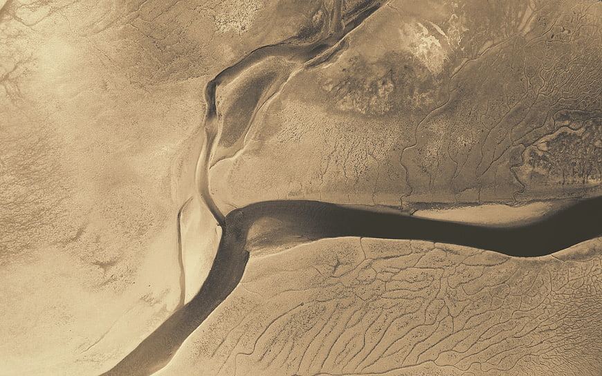 Aerial view of abstract sand dunes and dry riverbed patterns