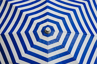 Blue and white striped beach umbrella top view