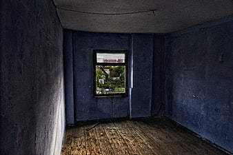 Empty abandoned room with blue walls and wooden floor