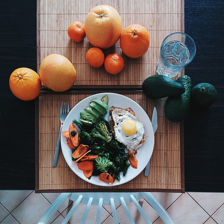 Healthy breakfast plate with eggs, avocado, and citrus fruits