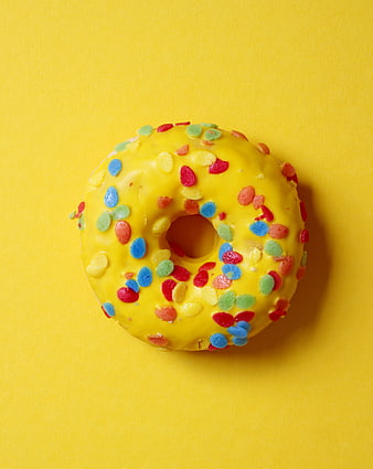 Yellow Glazed Donut With Colorful Sprinkles On Yellow Background