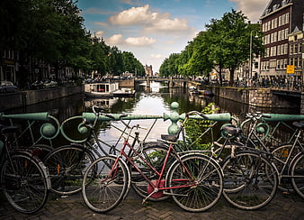 Bicycles parked on bridge overlooking Amsterdam canal