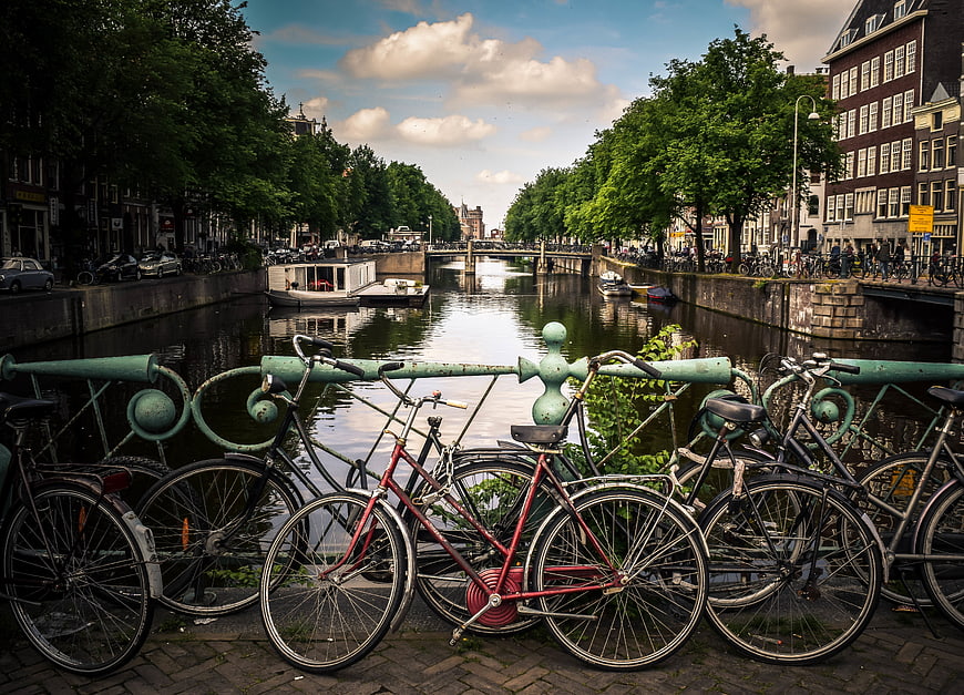 Bicycles parked on bridge overlooking Amsterdam canal