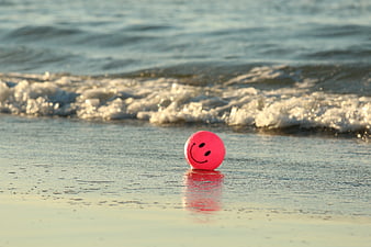 Pink Smiley Ball on Wet Sandy Beach Shore