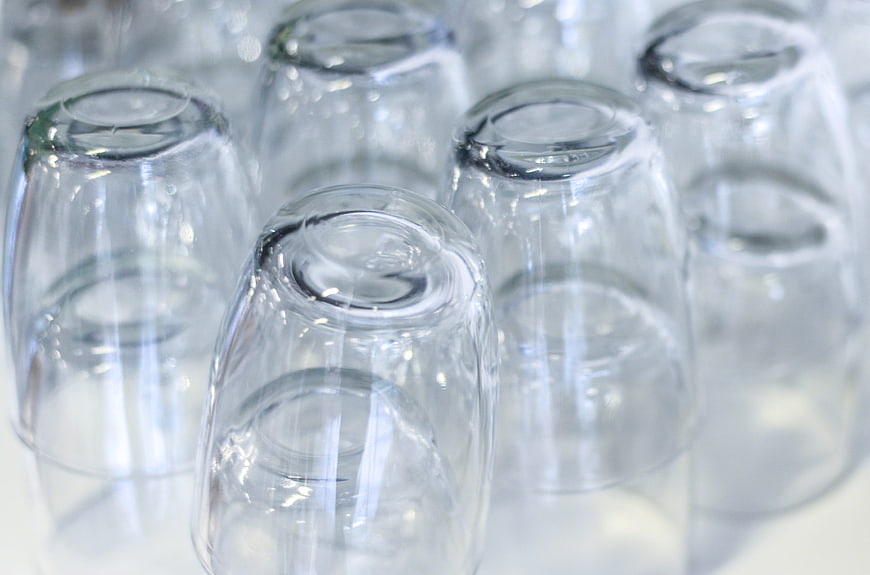Stacked clear drinking glasses on white surface