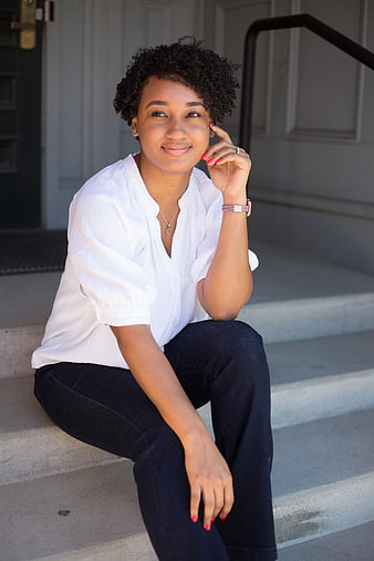 Smiling young woman sitting on outdoor concrete steps