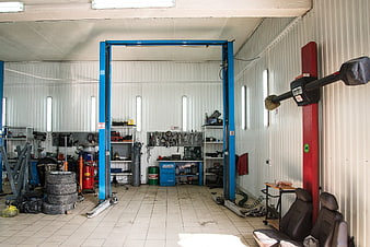 Interior of a professional automotive repair garage with car lift and tools