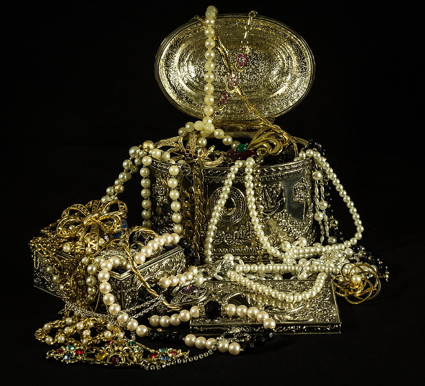 Vintage silver jewelry boxes overflowing with pearls and gold chains