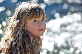 Portrait of a smiling girl with long wavy hair and freckles
