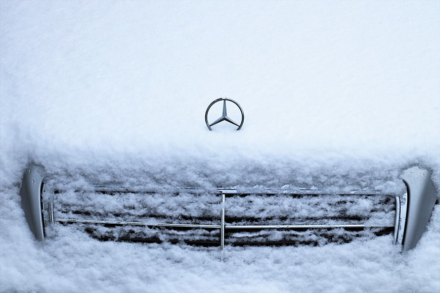 Mercedes-Benz car front grille buried in deep winter snow
